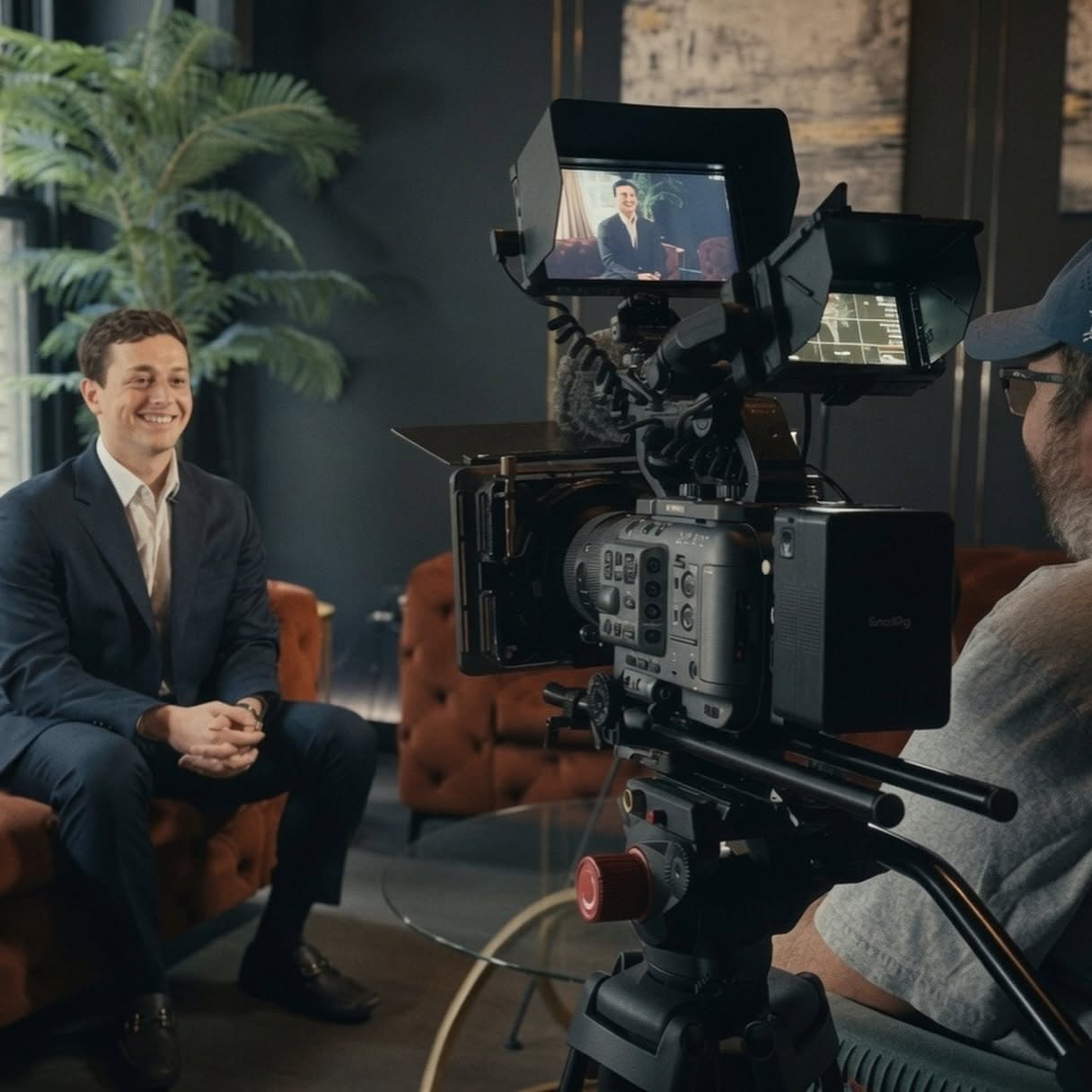 Hilltree interview setup with a subject seated in a lounge, framed on a cinema monitor